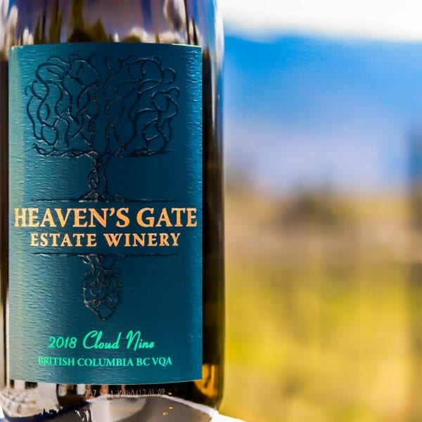 Closeup of the Heaven's Gate Estate Winery bottle of 2018 Cloud Nine wine with a blurred vineyard in the background